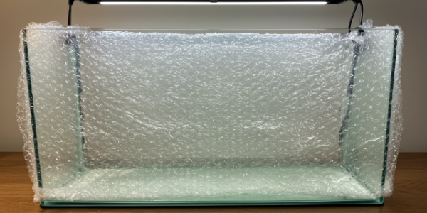 Aquarium inpakken met bubbeltjesfolie voor veilig transport